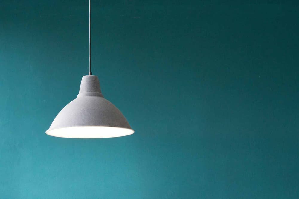 White pendant lamp over a teal wall