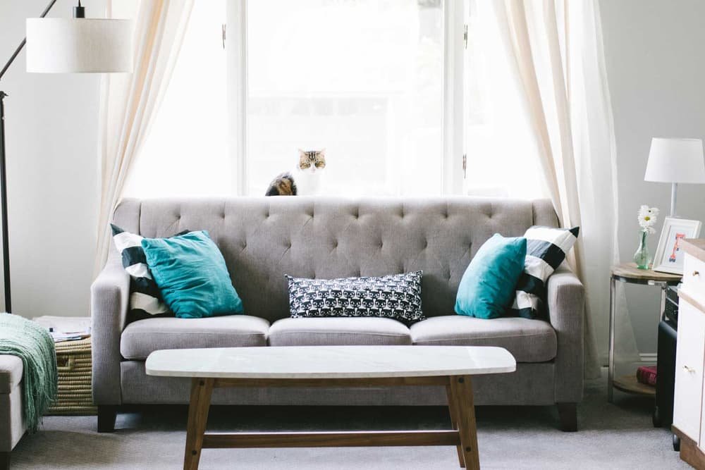 Living room with a grey sofa, teal cushions and a low table